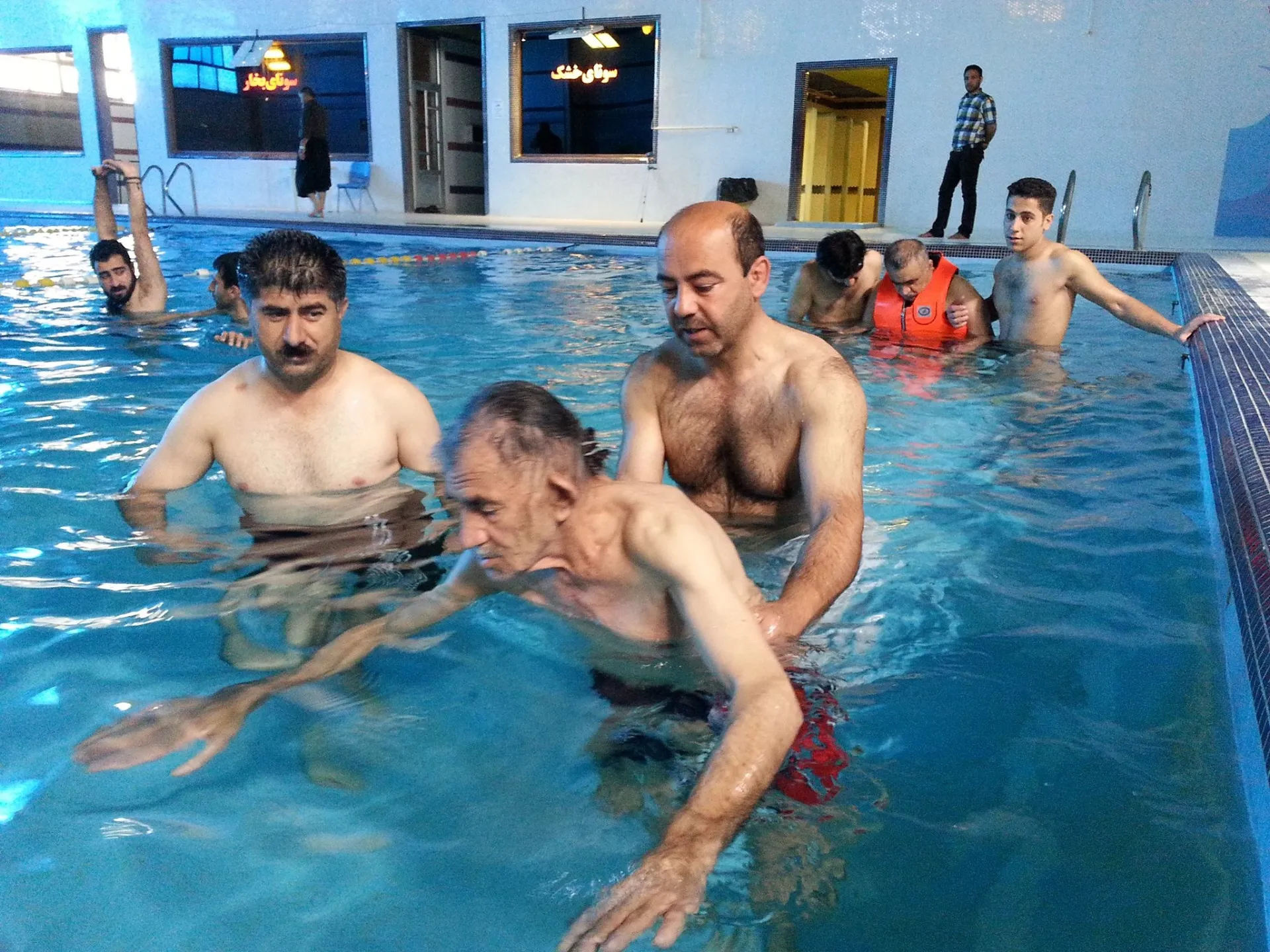 تمرین مرد پیر با مربی در استخر ایرانی